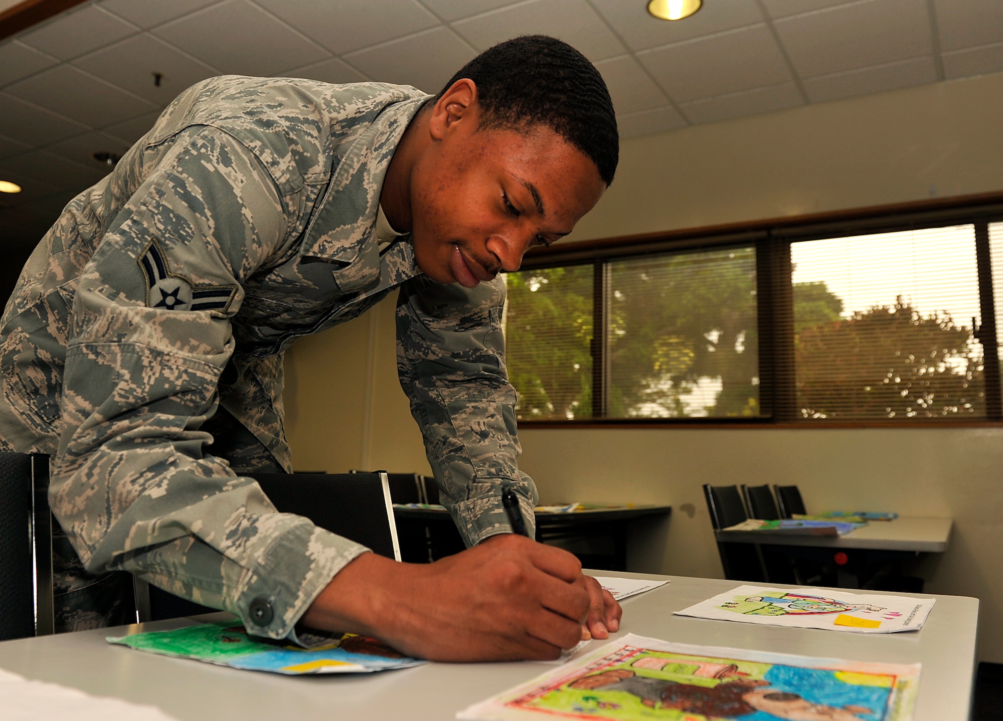 U.S. Air Force Airman 1st Class Paris Bell, 18th Operations Support Squadron airfield management operations coordinator, votes for submissions of the Earth Day art contest at the Schilling Community Center on Kadena Air Base, Japan, April 21, 2014. There was a total of 49 entries for the coloring contest and 27 entries for the poster, and the voting was open to everyone with base access. (U.S. Air Force photo by Naoto Anazawa)