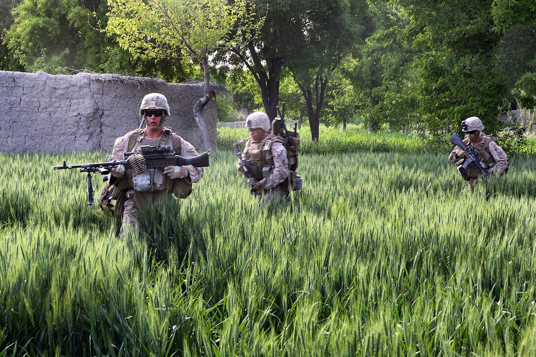 U.S. Marine Corps Lance Cpl. Shawn Madruga, foreground, leads Marines out of a field during a mission in Helmand province, Afghanistan, April 17, 2014. Madruga, a machine gunner, is assigned to Weapons Company, 1st Battalion, 7th Marine Regiment.