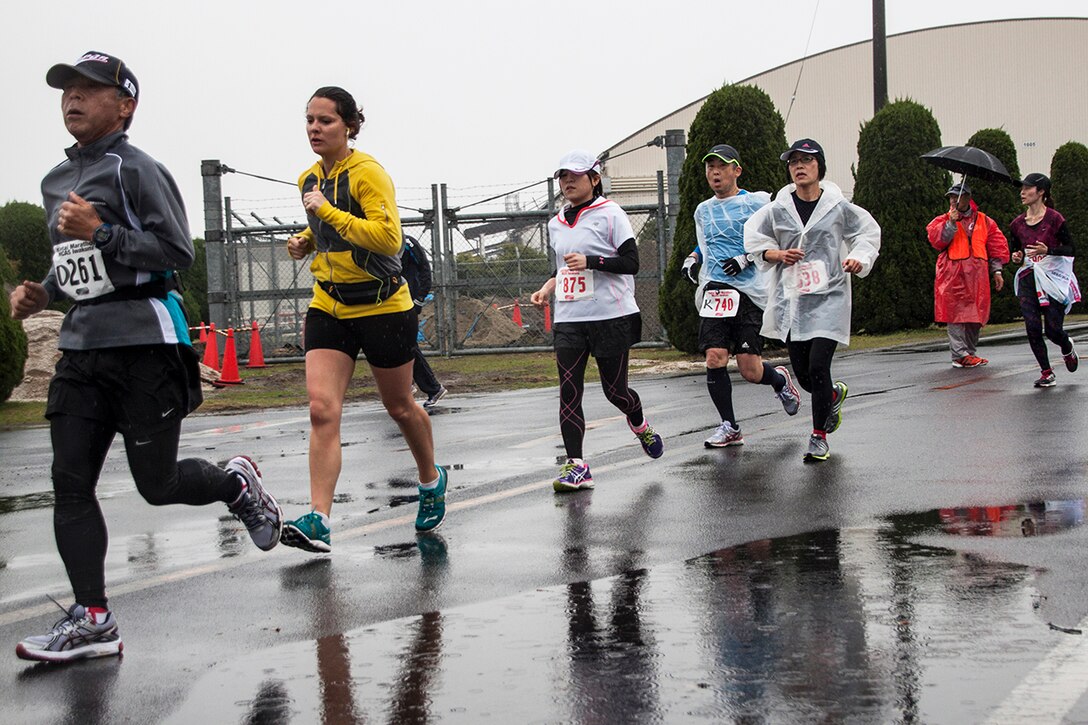 American and Japanese participants of the 2014 Kintai Marathon, which took place aboard Marine Corps Air Station Iwakuni, Japan, run past a puddle, April 13. The Kintai Marathon is one of the few annual events that give Japanese citizens an opportunity to come aboard station. Approximately 800 people signed up for the full marathon, half marathon and five-kilometer walk.