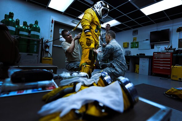 Physiological support technicians with the 99th Expeditionary Reconnaissance Squadron help Lt. Col Jeff Klosky don his high-altitude full pressure suit before flight April 20, 2014, in Southwest Asia. The full pressure suit provides protection to Klosky and other U-2 pilot, at extreme high altitudes. (U.S. Air Force photo/Tech. Sgt. Russ Scalf)