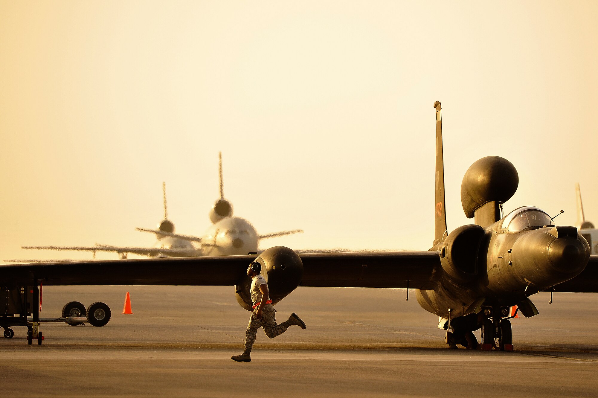 A member of the 380th Expeditionary Aircraft Maintenance Squadron assists in the removal of the temporary landing gear on a U-2 April 20, 2014, at a flightline in Southwest Asia. The U-2 utilizes temporary landing gear to reduce weight in flight. (U.S. Air Force photo/Tech. Sgt. Russ Scalf)