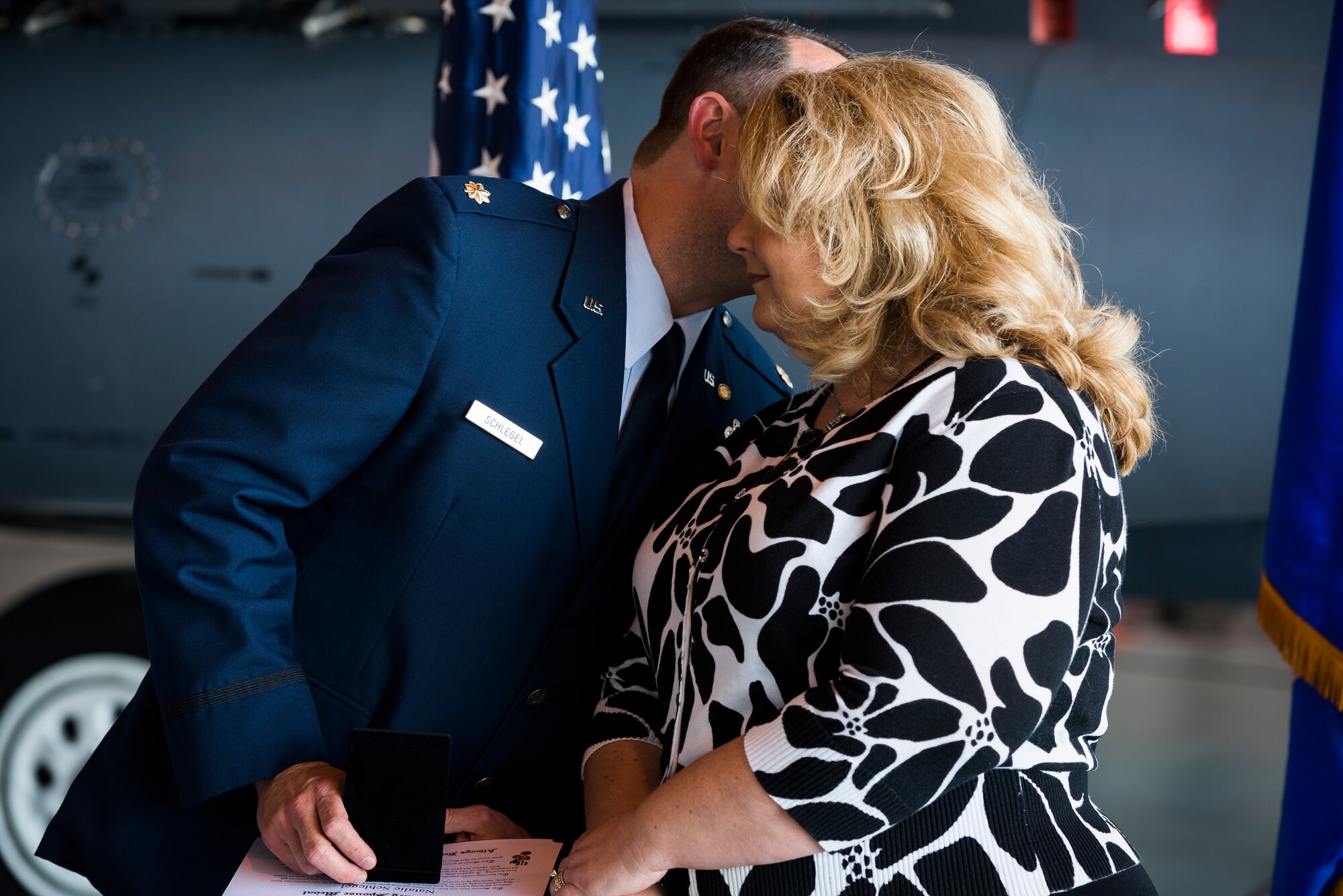 Maj. Edward Schlegel, 366th Aircraft Maintenance Squadron, kisses his wife, Natalie, on the cheek during his retirement ceremony April 18, 2014, at Mountain Home Air Force Base. He presented her with the Air Force spouse medal, thanking her for all the support she gave during his career. (U.S. Air Force photo by Tech. Sgt. Samuel Morse/RELEASED)