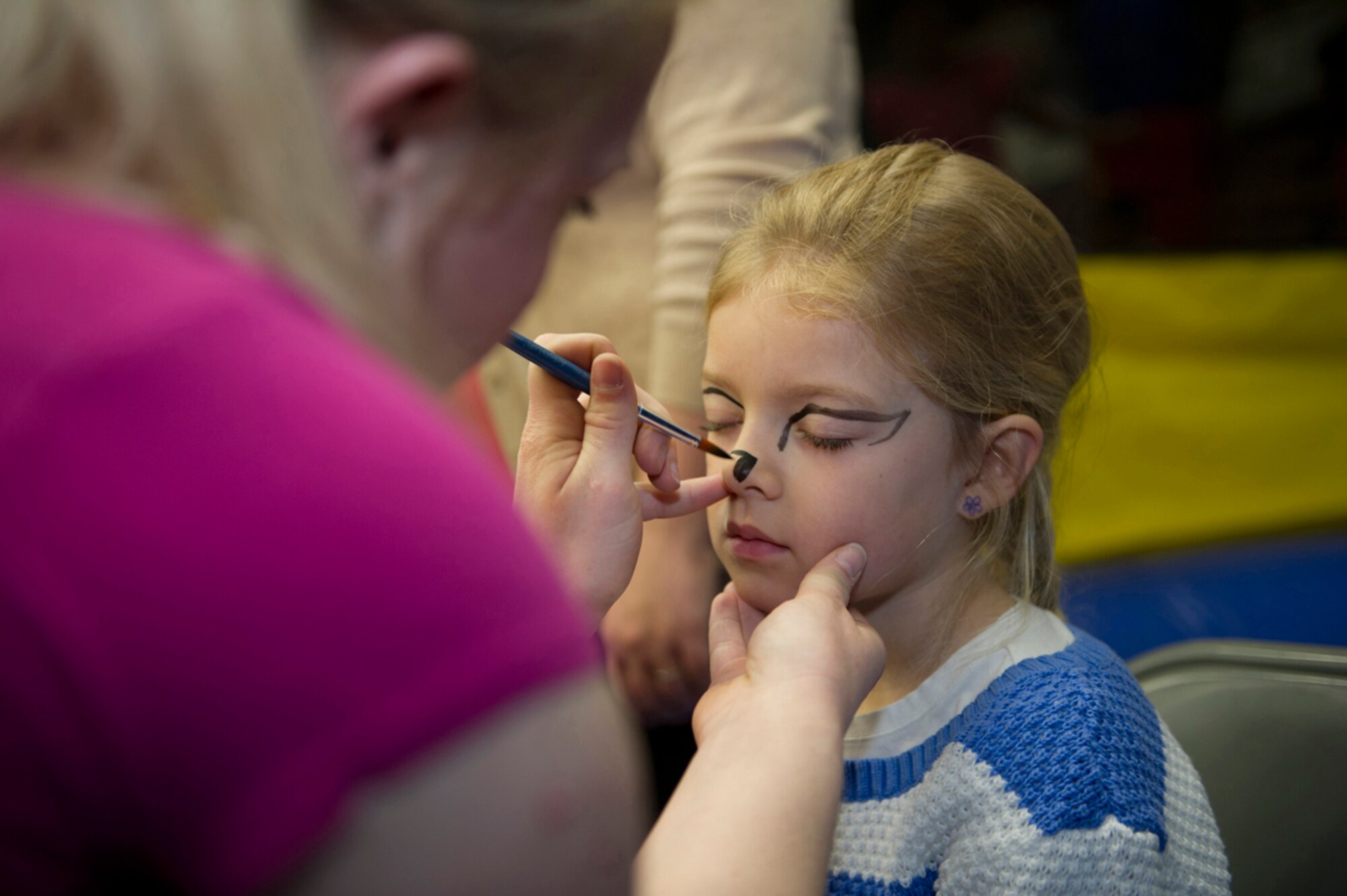 Lola Austin, 6, daughter of Airman 1st Class Zachary Austin and Nicole Austin, gets a face painting during the Family Fun and Fitness Fair inside the Buckner Physical Fitness Center on Joint Base Elmendorf-Richardson Saturday.  Families from across the installation came together for a day of fun and resiliency before Easter Sunday. (U.S. Air Force photo/Senior Airman Omari Bernard)