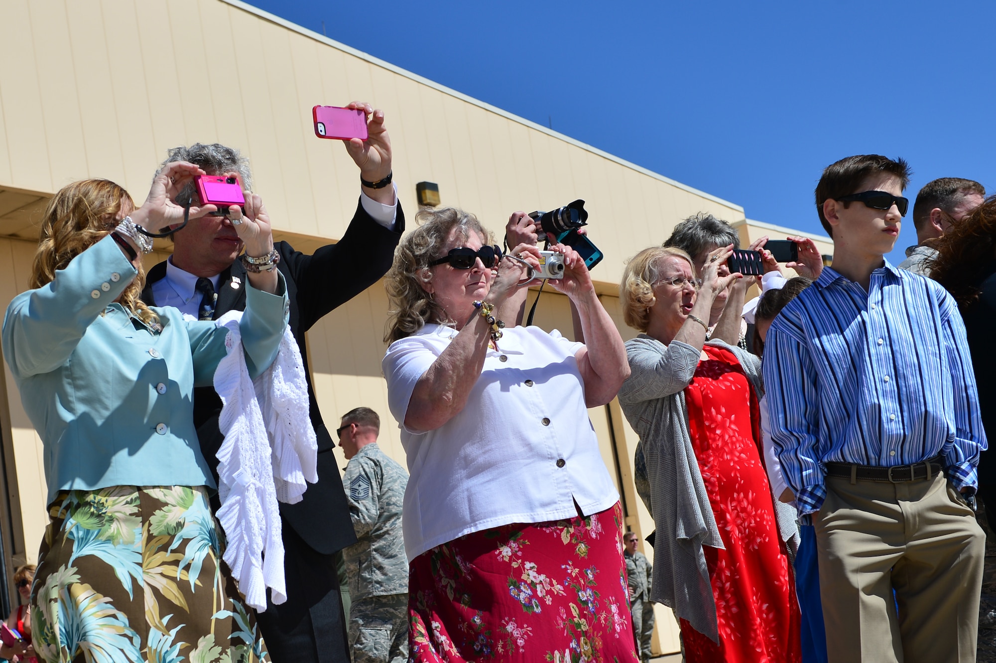 Onlookers use personal cameras to capture the arrival of members of the 26th Special Tactics Squadron, April 24, 2014 at Cannon Air Force Base, N.M. The 26 STS, formerly Detachment 1 of the 720th Special Tactics Group, Hurlburt Field, Fla., is a newly activated squadron based at Cannon.. (U.S. Air Force photo/ Senior Airman Eboni Reece)