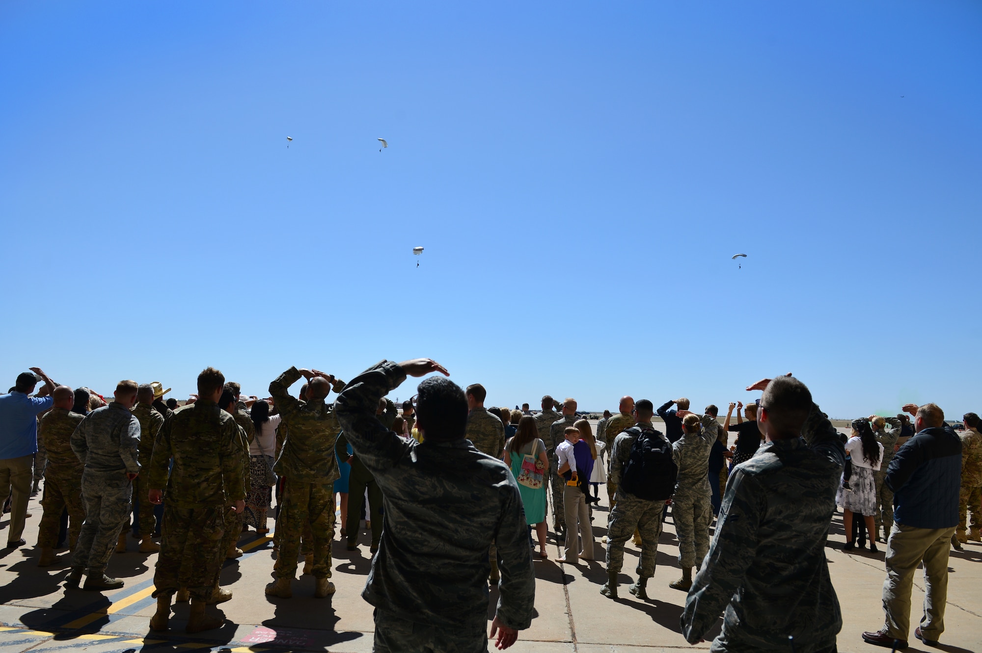 Spectators watch as members of the 26th Special Tactics Squadron parachute onto the flightline, April 24, 2014 at Cannon Air Force Base, N.M. The 26 STS, formerly Detachment 1 of the 720th Special Tactics Group, Hurlburt Field, Fla., is a newly activated squadron based at Cannon. (U.S. Air Force photo/ Senior Airman Eboni Reece)