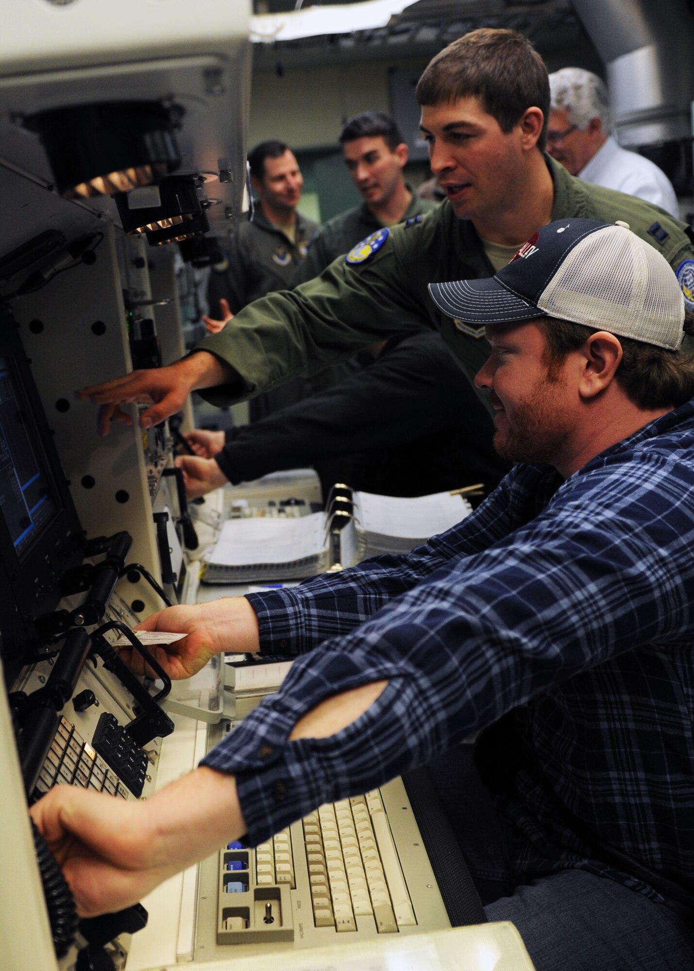 Capt. Joshua Frider, 341st Operations Support Squadron ICBM instructor combat crew commander, shows Chad Swift, KRTV account executive of sales, a simulated key turn in the missile procedures trainer April 17. More than 30 Great Falls leaders had the opportunity to visit a missile maintenance trainer, armory, MPT, fitness center and dining facility during a Leadership Great Falls class tour. (U.S. Air Force photo/Senior Airman Katrina Heikkinen) 