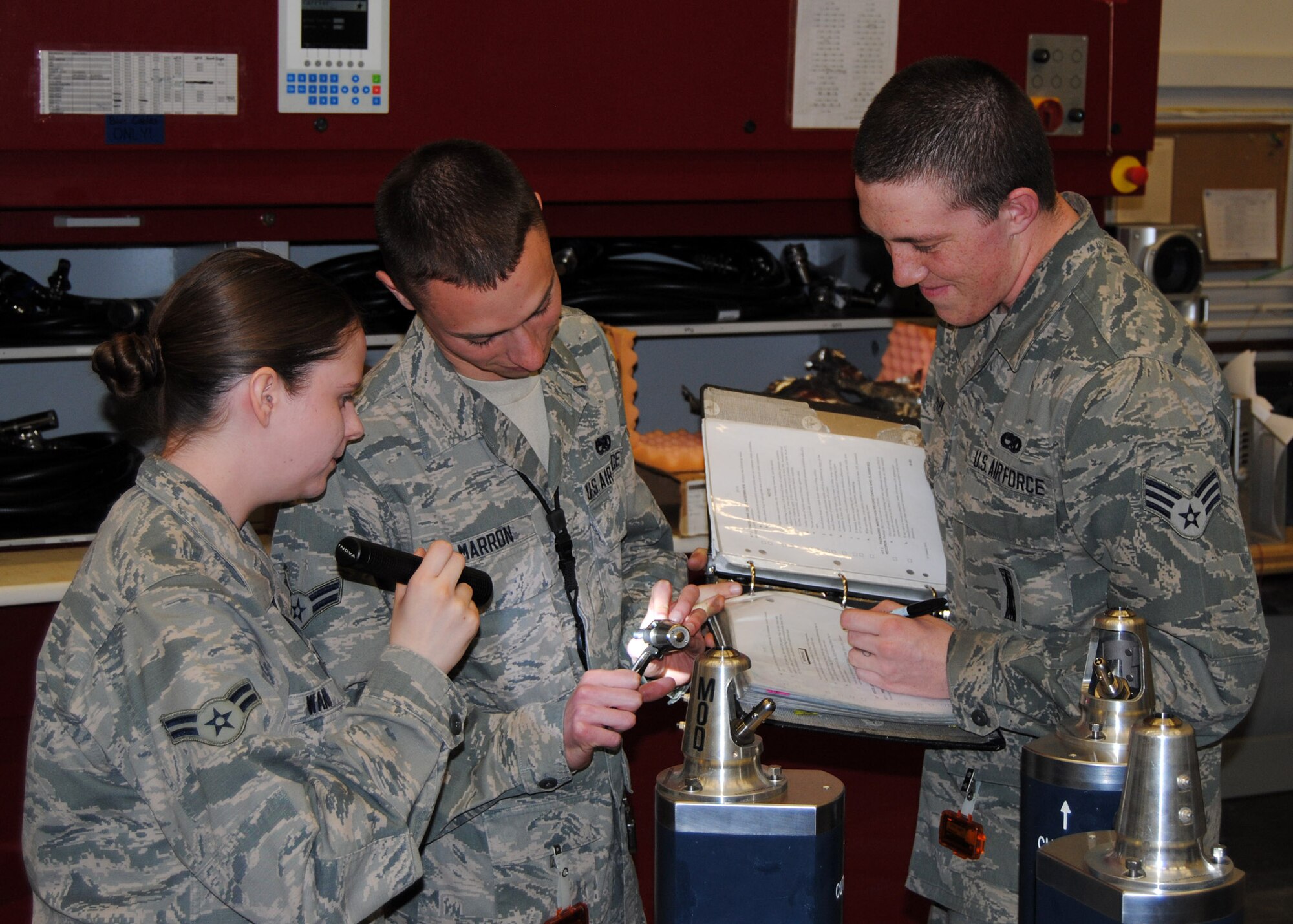 Airman 1st Class Rachel Ward, 341st Munitions Squadron member (left), Airman 1st Class Nicholas Marron, 341st MUNS reentry system reentry vehicle maintainer (center), and Senior Airman Austin Park, 341st MUNS member, inspect a zero impulse bolt while following a technical order at Bldg. 1840 in the Weapons Storage Area on April 23. Marron was recently accepted into the Air Force Academy Preparatory School and will leave Malmstrom in July. (Courtesy photo)