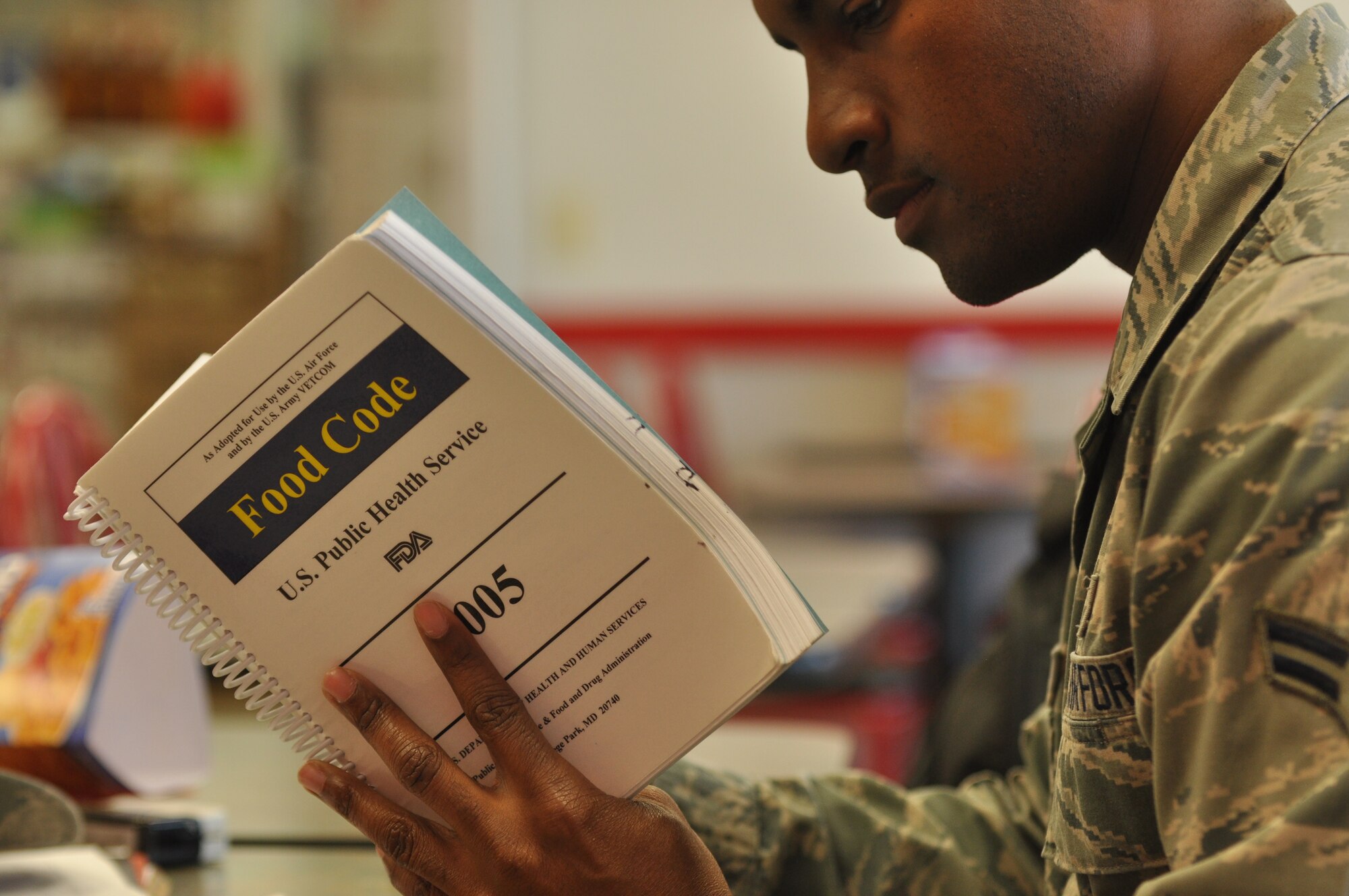 Airman 1st Class Devante Scarver, a 19th Aerospace Medicine Squadron Public Health technician, reviews the U.S. Public Health Services Food Code manual April 15, 2014, during a health inspection at Little Rock Air Force Base, Ark. Scarver conducts approximately 25 – 30 health inspections on base per month. (U.S. Air Force photo by Senior Airman Regina Agoha)