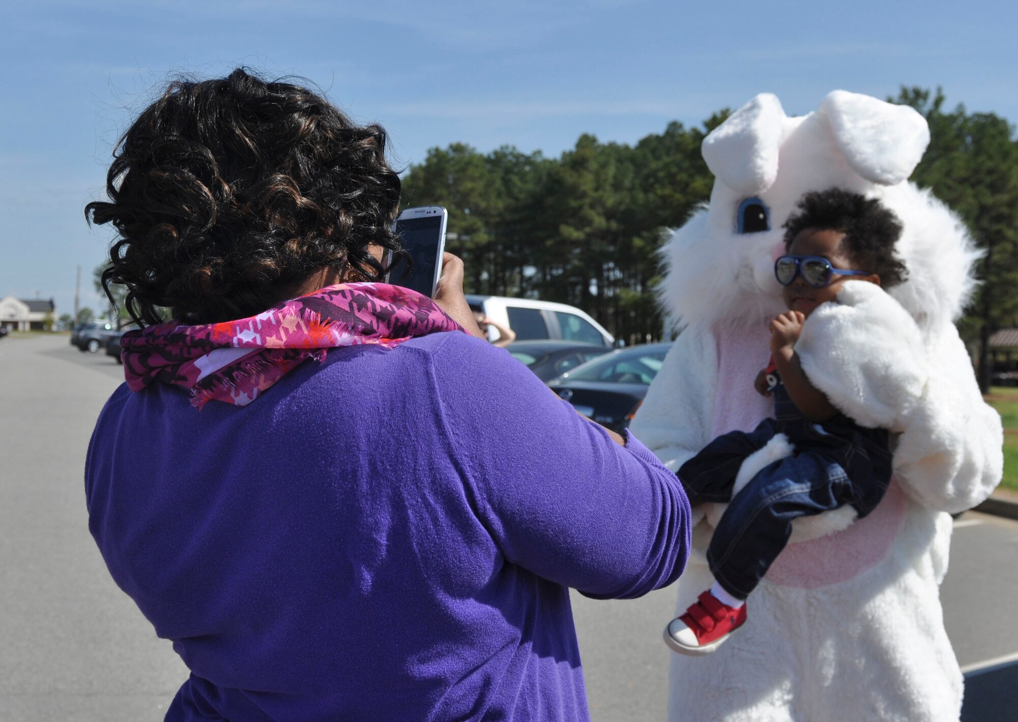 Krystal Mills, an Army spouse, takes a photo of her son, Michael, with an Easter bunny April 19, 2014, during Family Fest at Little Rock Air Force Base, Ark. Along with several Easter bunnies hopping around during the event, McGruff the Crime Dog was also in attendance. (U.S. Air Force photo by Senior Airman Regina Agoha)