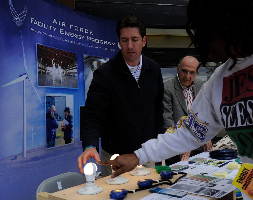 Aaron Sprouse and Mohammad Alikhani share energy conservation tips with Rena Hawk at the base exchange on Joint Base Andrews, Md., April 23, 2014. In honor of Earth Day, Sprouse, the pollution prevention program manager, and Alikhani, the energy manager for the 11th Civil Engineer Squadron, educated JBA members on base environmental programs. JBA has reduced its energy intensity 55% from 2003-2013, said Alikhani. (U.S. Air Force photo/ Senior Airman Nesha Humes)