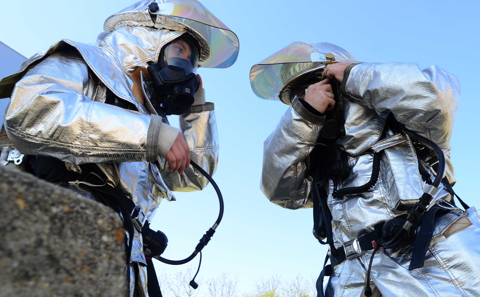 U.S. Air Force Staff Sgt. Chad Green and Airman 1st Class Britt Beshear, 633rd Civil Engineer Squadron Fire Department firefighters, don fire protective gear during a simulated aircraft fire at Langley Air Force Base, Va., April 23, 2014. Airmen from the 633rd CES shared best practices with a Royal Netherlands Air Force counterpart to foster relationships and increase capabilities. (U.S. Air Force photo by Staff Sgt. Antoinette Gibson/Released)