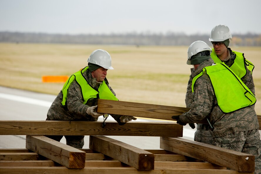 Airmen from the 910th Maintenance Squadron assemble a dunnage system under the wing of a C-130 Hercules aircraft during a Major Accident Readiness Exercise here, April 23, 2014. The dunnage system supports large airbags that can be inflated to lift the aircraft. The Airmen were part of the Crash, Damaged, Disabled, Aircraft Recovery (CDDAR) team. In the exercise scenario, the C-130 aircraft’s landing gear collapsed while landing on the assault strip. Debris from the aircraft hit a private aircraft taxiing nearby. Base emergency response personnel tested their response capability while Wing Inspection Team (WIT) members observed. U.S. Air Force photo/Eric M. White.