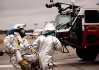 Youngstown Air Reserve Station firefighters carry a simulated victim from a C-130 to a triage area during a Major Accident Readiness Exercise here, April 23, 2014. In the exercise scenario, a C-130 aircraft’s landing gear collapsed while landing on the assault strip. Debris from the aircraft hit a private aircraft taxiing nearby. Base emergency response personnel tested their response capability while Wing Inspection Team (WIT) members observed. U.S. Air Force photo/Eric M. White.