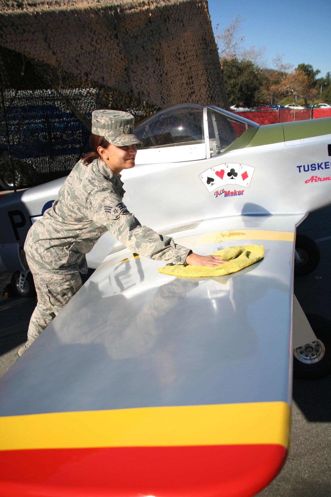 Senior Airman Paige McCann, a member of the 452d Communications Squadron,
March ARB, polishes the right wing of a miniature P-51 Mustang aircraft on Dec. 31,
2013. McCann and other March airmen volunteered to educate the public about the
WWII Tuskegee airmen and the P-51 Mustang aircraft during the 125th Pasadena
Tournament of Roses Rose Parade Expo Village. (U.S. Air Force photo/Senior Airman Russell S. McMillan)
