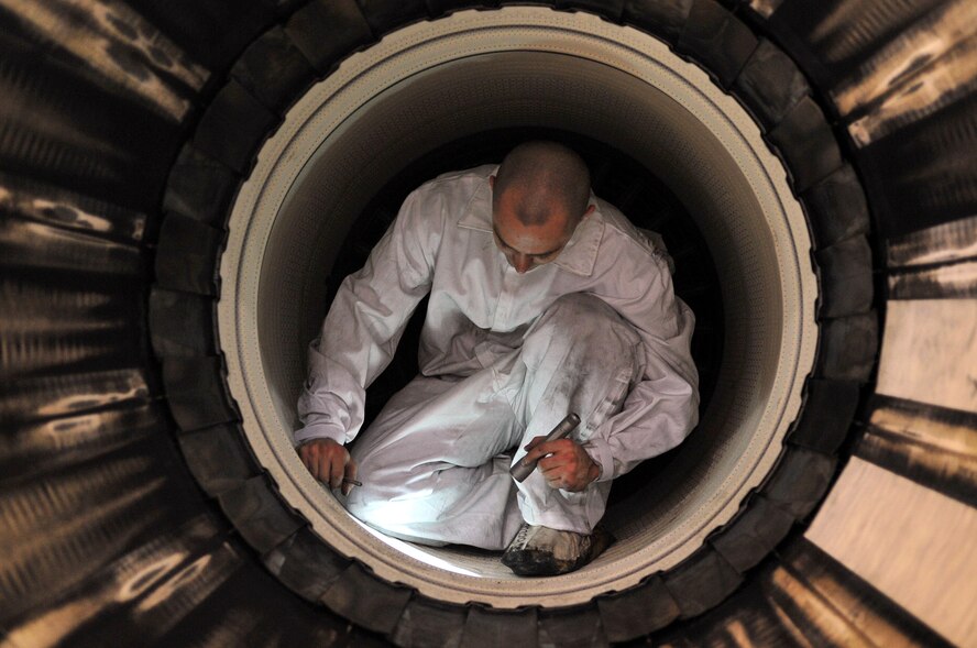Senior Airman Russell White, 4th Component Maintenance Squadron propulsion flight journeyman, inspects the augmenter liner of an F-15E Strike Eagle engine, April 10, 2014, at Seymour Johnson Air Force Base, N.C. The propulsion flight is responsible for supplying war-ready engines in support of more than 90 F-15E aircraft by inspecting, tearing down, and building the engines. (U.S. Air Force photo/Airman 1st Class Shawna L. Keyes)
