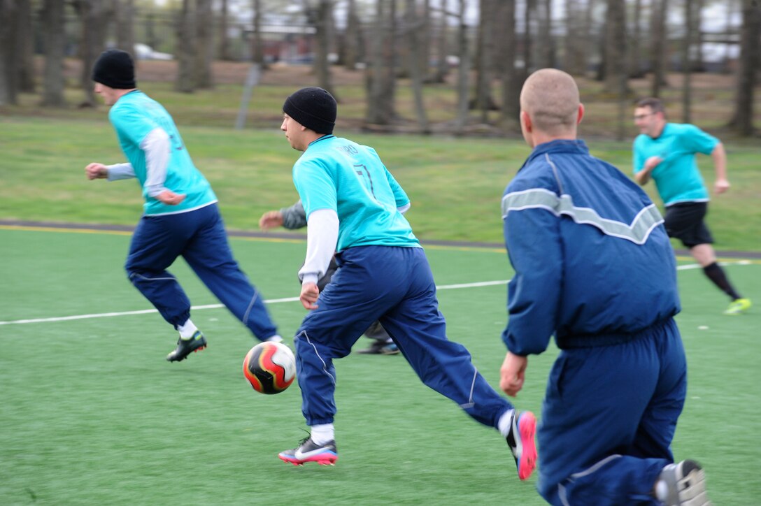 Service members run downfield during a scrimmage April 18, 2014, at Joint Base Andrews, Md. The Civil Engineer Futbol Club meets every Friday morning during physical training and sometimes after work to practice their skills, relieve stress, build camaraderie, and get a workout. (U.S. Air Force photo by Senior Airman Mariah Haddenham/ Released)  
