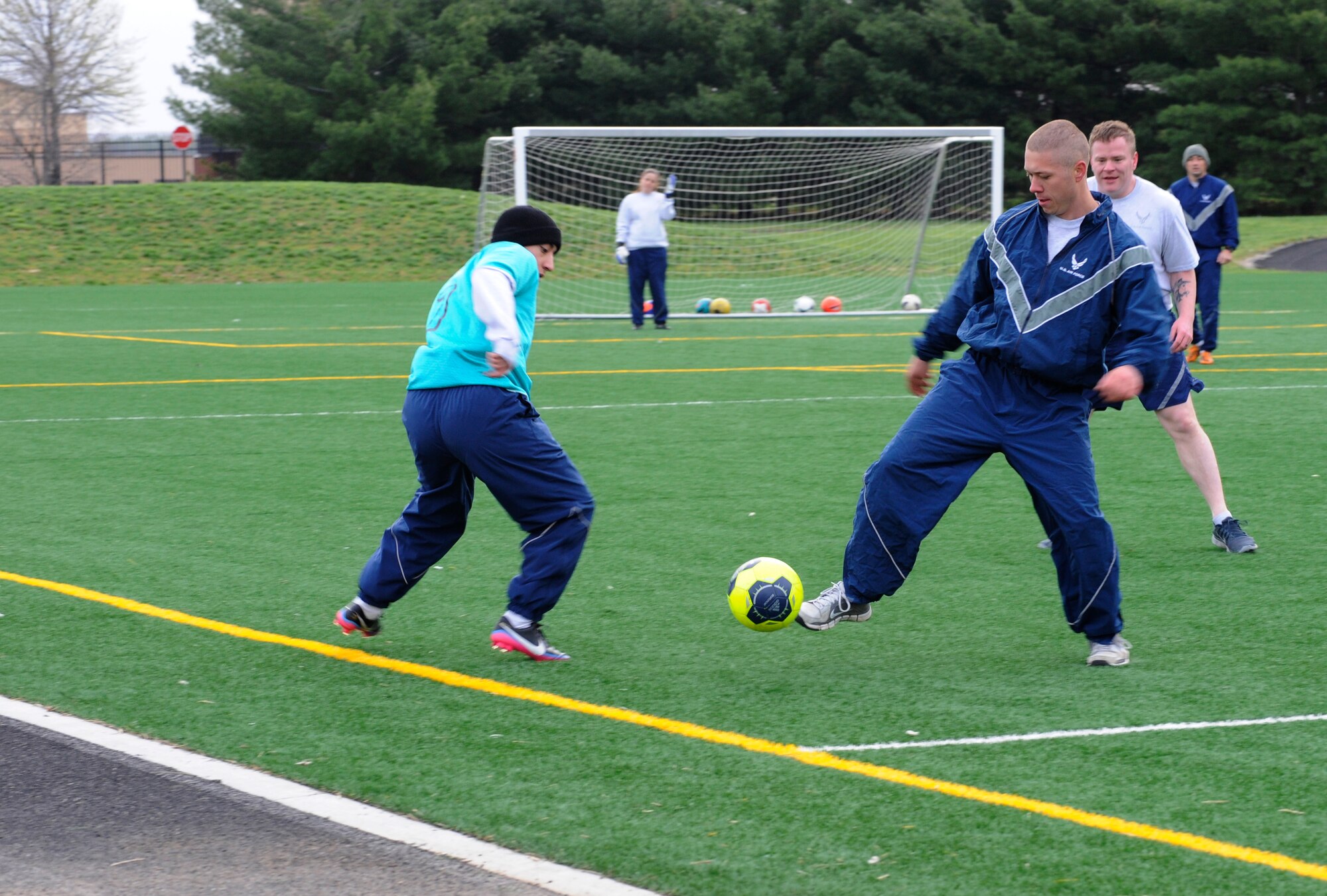 Airman Matthew Vantubbergen, 11th Civil Engineer Squadron water and fuels maintenance specialist,  kicks a soccer ball during a scrimmage April 18, 2014, at Joint Base Andrews, Md. The Civil Engineer Futbol Club meets every Friday morning during physical training and sometimes after work to practice their skills, relieve stress, build camaraderie, and get a workout. (U.S. Air Force photo by Senior Airman Mariah Haddenham/ Released)