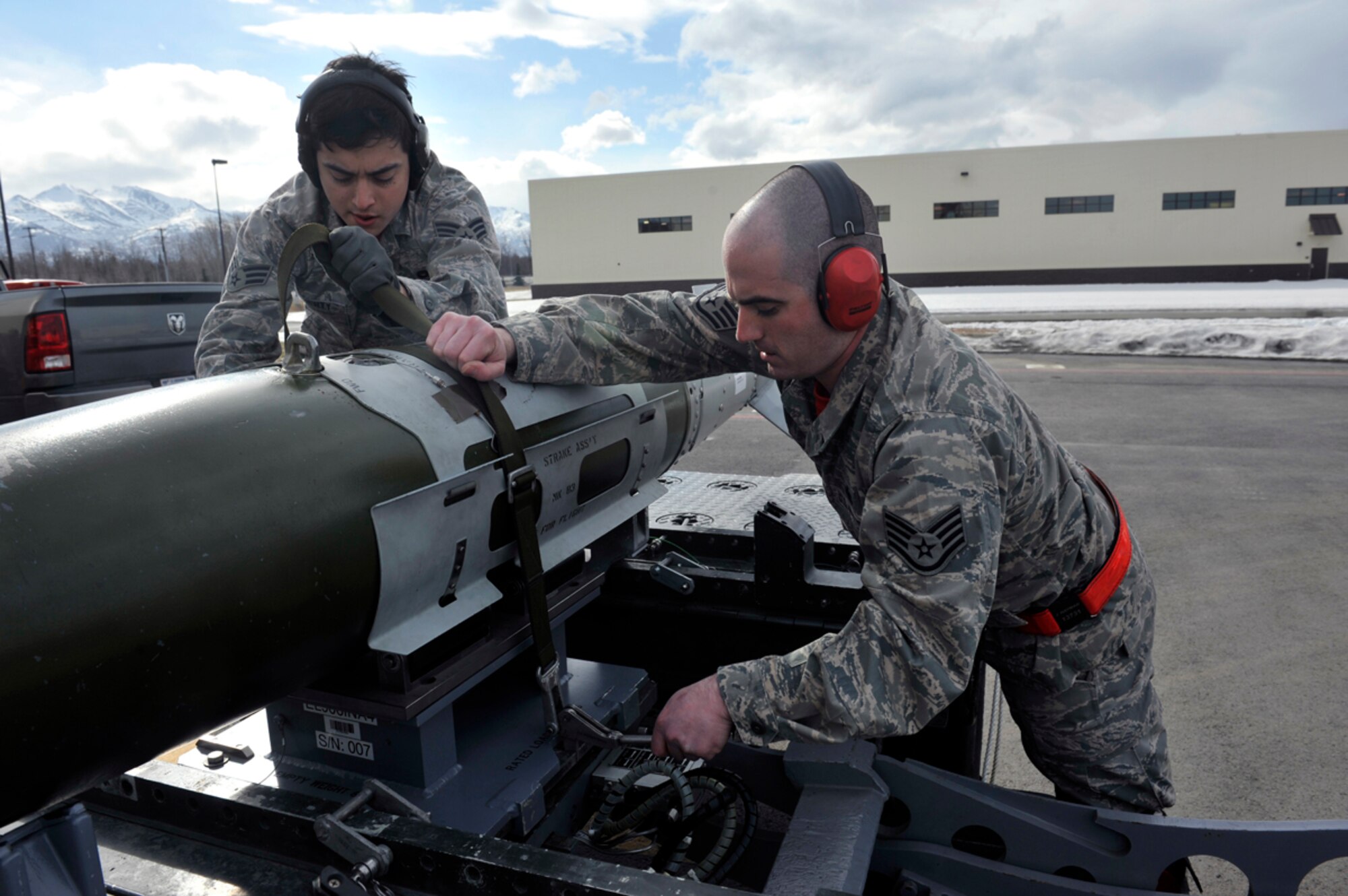 Air Force Staff Sgt. Jarrett Hayman, 90th Aircraft Maintenance Unit weapons load team crew chief, and Senior Airman Stephan Doherty, weapons load crew member, strap a Guided Bomb Unit-32 bomb to an MJ-1 Lift Truck during a 3rd Maintenance Group load crew competition on Joint Base Elmendorf-Richardson, Alaska, April 18, 2014. The MJ-1 Lift Truck was used to transport the GBU-32 into the main weapons bay of an F-22 Raptor. (U.S. Air Force photo/Airman 1st Class Tammie Ramsouer)