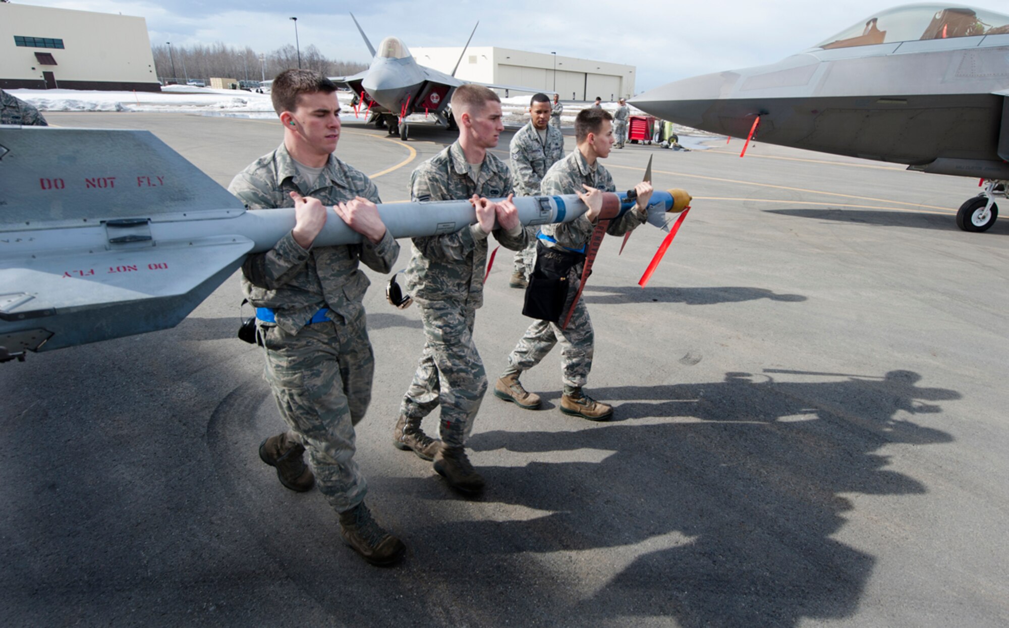 A load crew team from the 525th Aircraft Maintainence Unit carries an AIM-120 Sidewinder missile during a 3rd Maintenance Group load crew competition at Joint Base Elmendorf-Richardson, Alaska, April 18, 2014. The 90th and 525th aircraft maintenance units train regularly to be proficient at their jobs, including competing in quarterly loading competitions. (U.S. Air Force photo/Staff Sgt. Robert Barnett)