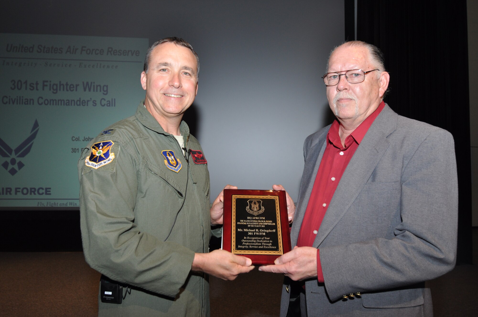 Mr. Michael Oringderff, 301st Fighter Wing Financial Management Comptroller, accepts the Major General Frank R. Faykes Financial Management and Comptroller of the Year FY 2013 from Col. John Breazeale, 301st FW commander, at a ceremony April 7, 2014.
