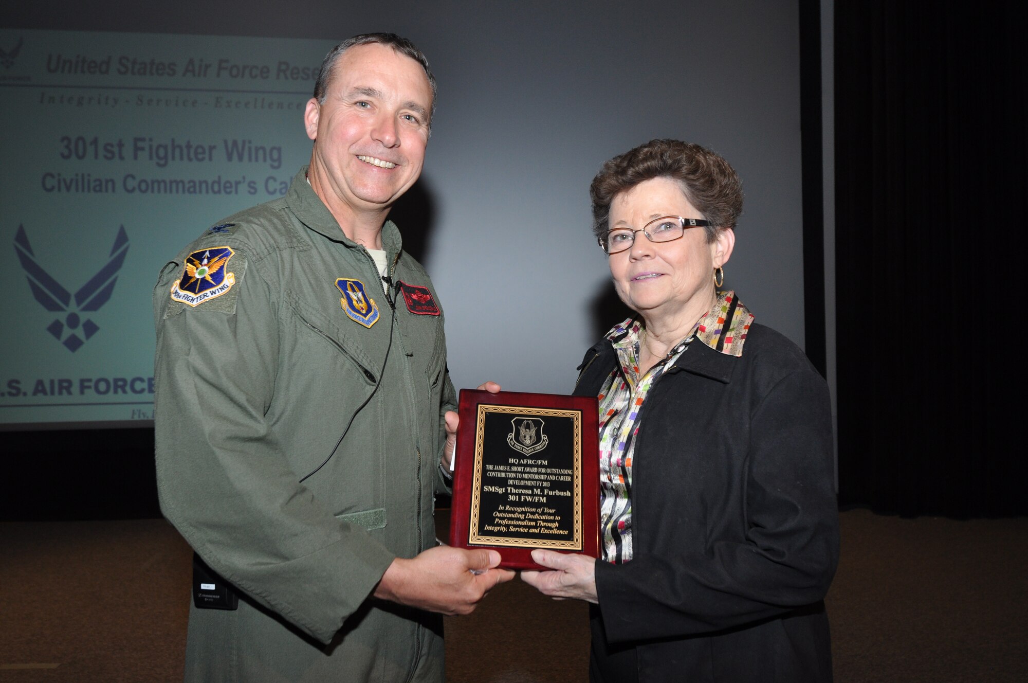Ms. Bobbie Munsell, 301st Fighter Wing Financial Management, accepts the James E. Short Award for Outstanding Contribution to Mentorship and Career Development FY 2013 on behalf of Senior Master Sgt. Theresa Furbush from Col. John Breazeale, 301st FW commander, at a ceremony April 7, 2014.