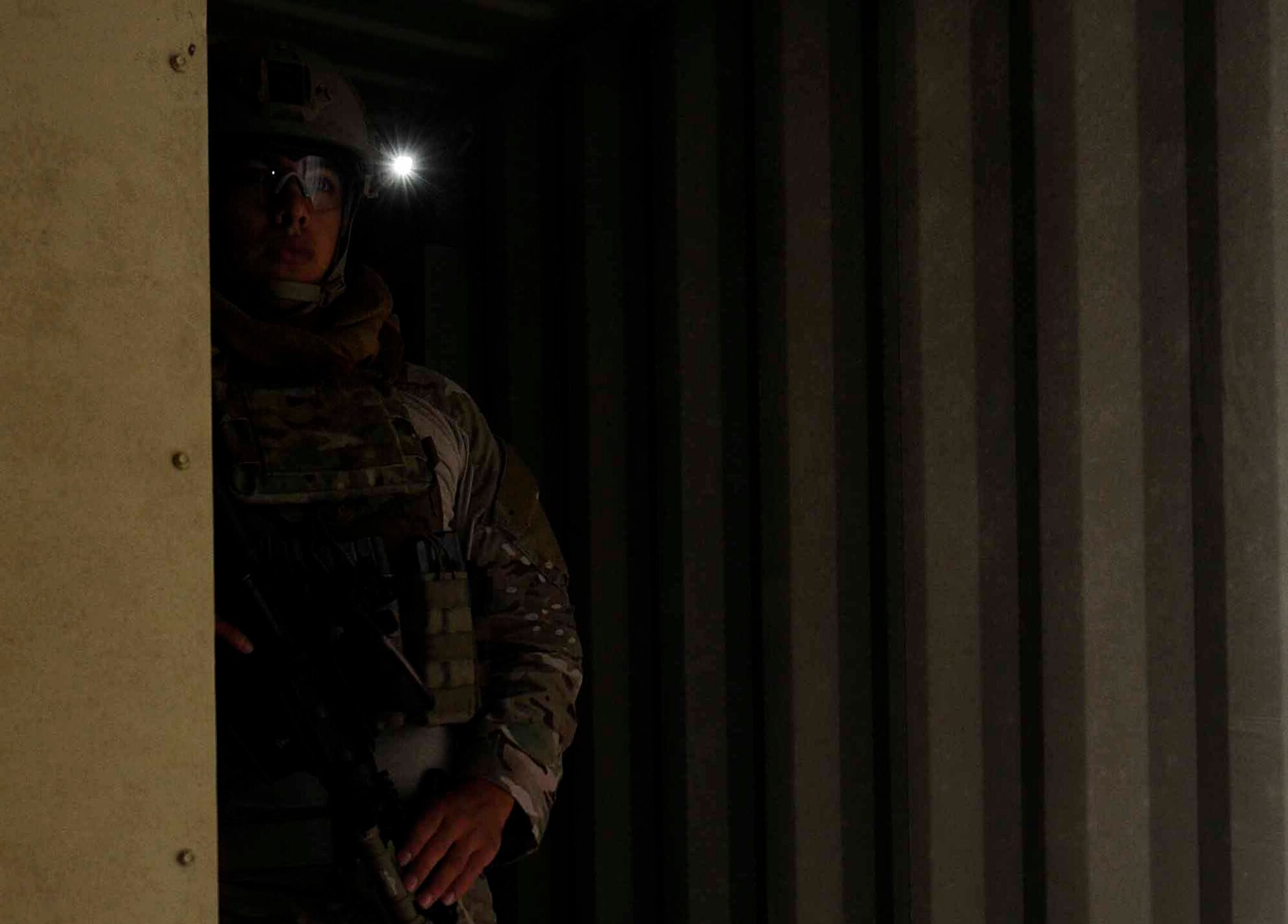 A 1st Special Operations Civil Engineer Squadron explosive ordnance disposal team member peeks around a corner at Hurlburt Field, Fla., April 24, 2014. During the training scenario, the EOD team secured a bunker after saving hostages with bombs strapped to their chests. (U.S. Air Force photo/Airman 1st Class Andrea Posey)
