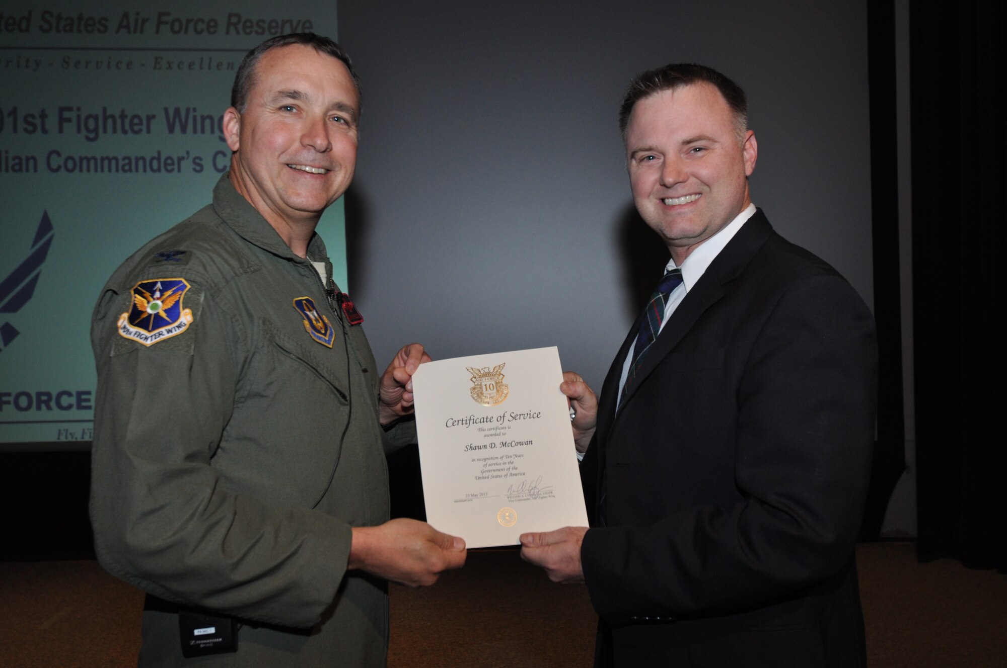 Mr. Shawn McCowan, 301st Fighter Wing Public Affairs, receives his 10-year pin and certificate for civilian service from Col. John Breazeale, 301st FW commander, at a ceremony April 7, 2014.