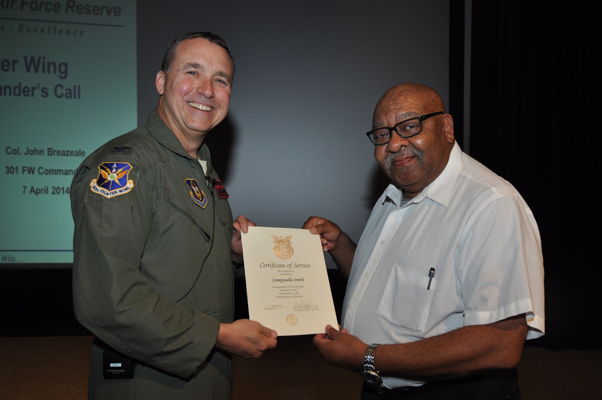 Mr. Campynella Smith, 301st Fighter Wing Information Protection, receives his 20-year pin and certificate for civilian service from Col. John Breazeale, 301st FW commander, at a ceremony April 7, 2014.