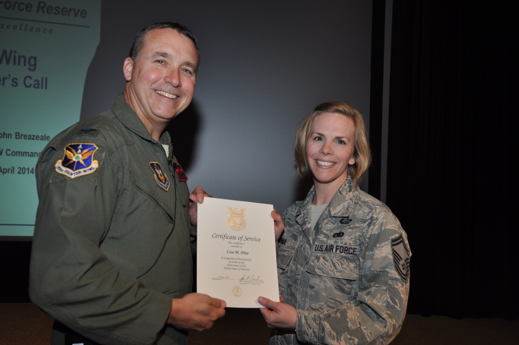Senior Master Sgt. Lisa Pina, 301st Maintenance Group's supervisor, log and maintenance supply specialist, receives her 20-year pin and certificate for civilian service from Col. John Breazeale, 301st Fighter Wing commander, at a ceremony April 7, 2014.