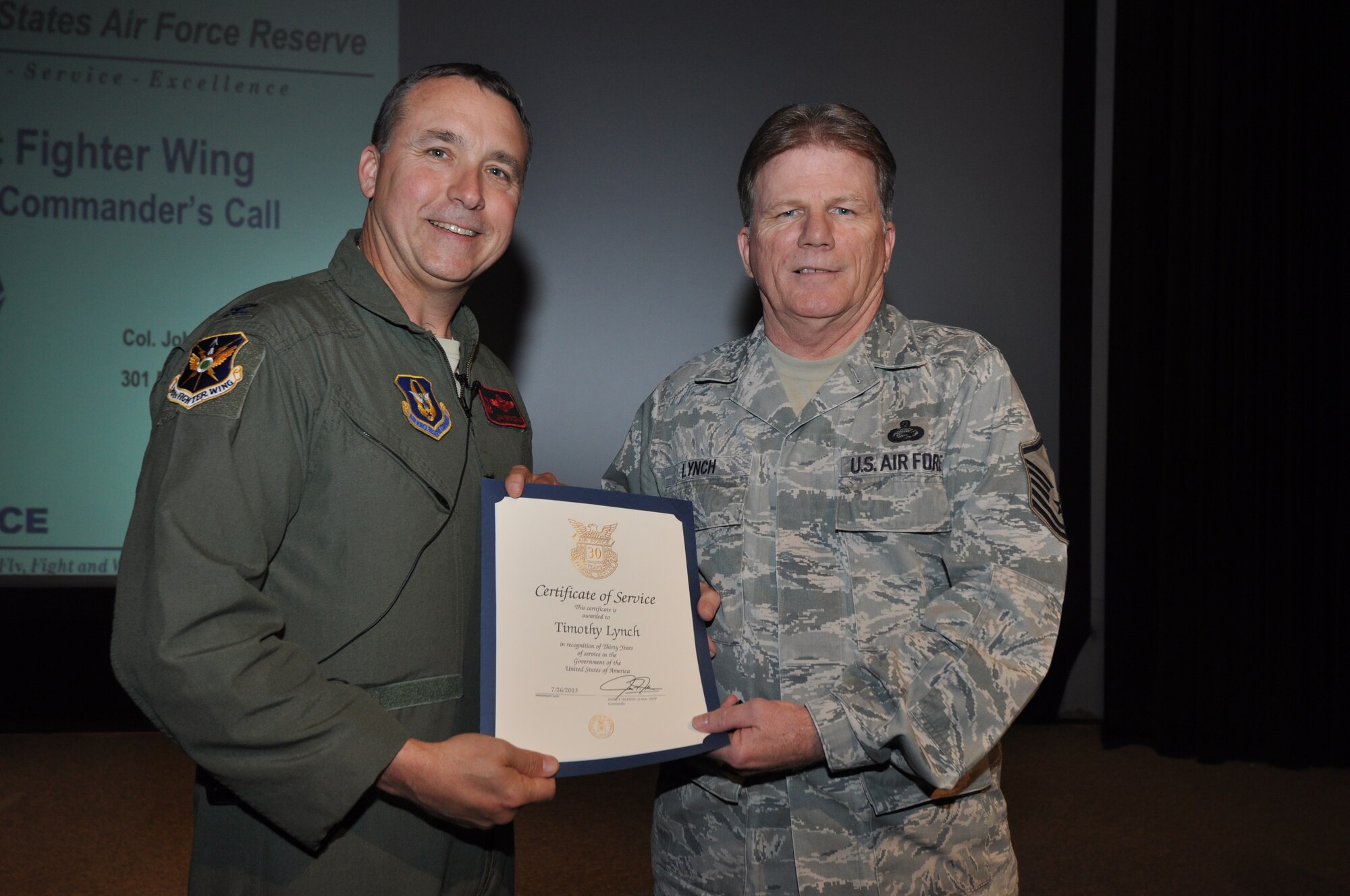 Master Sgt. Timothy Lynch, 301st Fighter Wing Career Assistant Advisor, receives his 30-year pin and certificate for civilian service from Col. John Breazeale, 301 FW commander, at a ceremony  April 7, 2014.