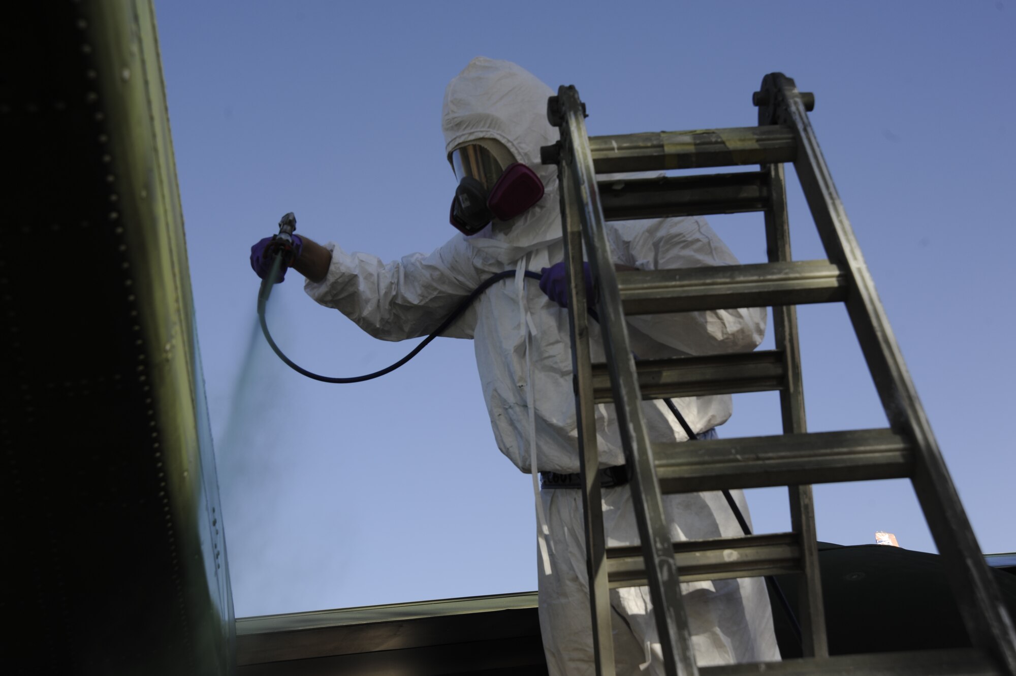 U.S. Air Force Senior Airman Edward Lawrence, 355th Equipment Maintenance Squadron aircraft structural maintenance, spray paints an OV-10A Bronco at Davis-Monthan Air Force Base, Ariz., April 24, 2014. A team of six Airmen sanded down the aircraft, repaired any damage they could and applied a new coat of paint. (U.S. Air Force photo by Airman 1st Class Betty R. Chevalier/Released)