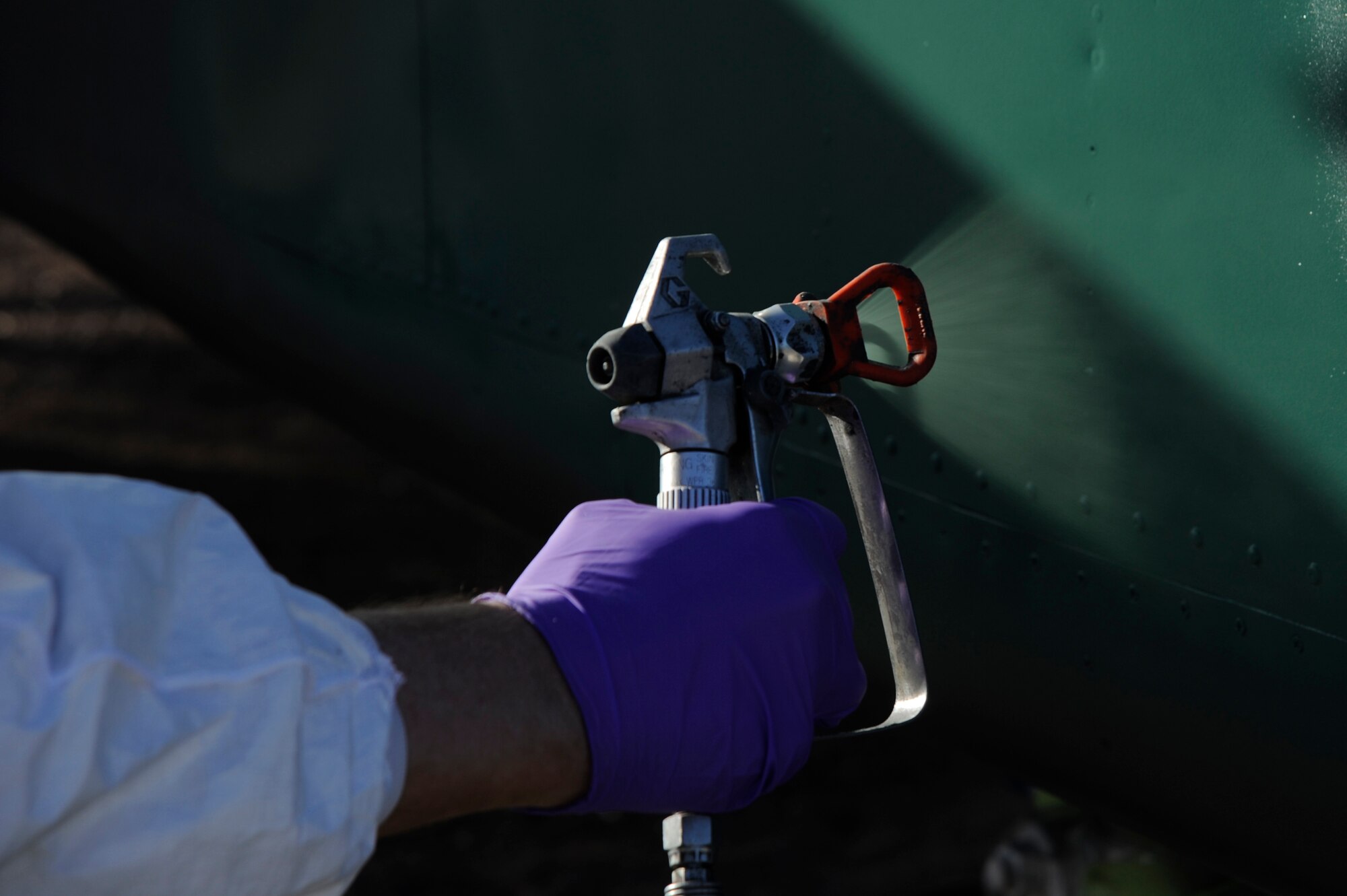 U.S. Air Force Senior Airman Edward Lawrence, 355th Equipment Maintenance Squadron aircraft structural maintenance, spray paints an OV-10A Bronco at Davis-Monthan Air Force Base, Ariz., April 24, 2014. The aircraft was chosen for restoration due to the amount of fading paint and deteriorated metal. (U.S. Air Force photo by Airman 1st Class Betty R. Chevalier/Released)