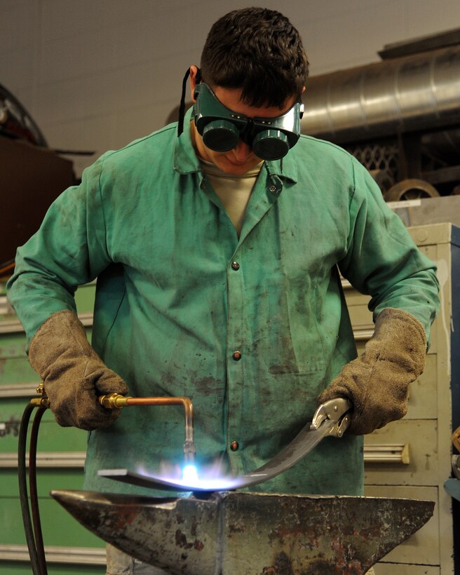 Senior Airman Dawid Michal Mludzik, 319th Civil Engineer Squadron structural craftsman, uses a torch to re-fabricate steel April 23, 2014, at the welding shop on Grand Forks Air Force Base, N.D. Mludzik is the Warrior of the Week for the fourth week of April, 2014. (U.S. Air Force photo/Senior Airman Zachiah Roberson)