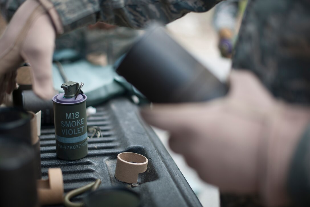 A member of the 11th Civil Engineer Squadron Explosive Ordnance Disposal unit prepares M18 smoke grenades for training here, April 17.  (U.S. Air Force photo/Staff Sgt. Robert Cloys)