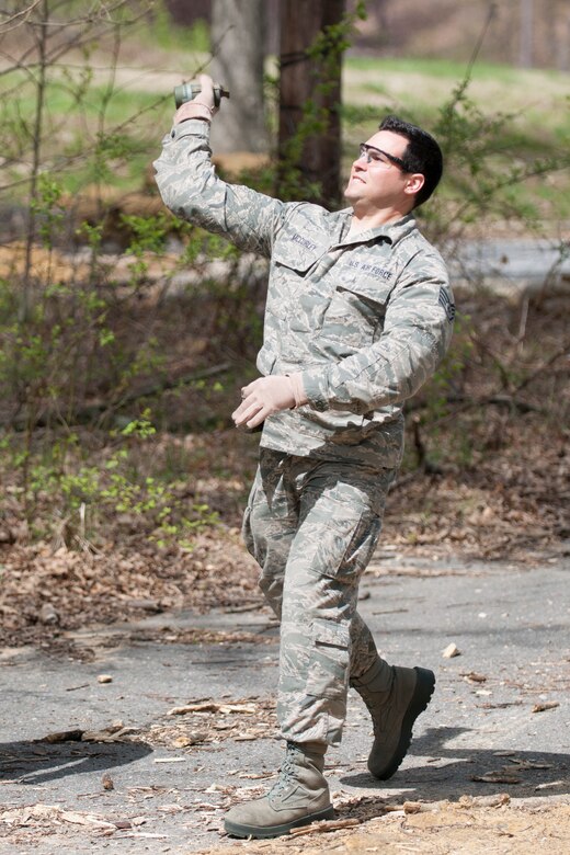 Staff Sgt. Jesse McCarley, 113th Wing Operations Support Flight, throws a M18 smoke grenade during training with the 11th Civil Engineer Squadron Explosive Ordnance Disposal unit on the east side of Joint Base Andrews, April 17.  (U.S. Air Force photo/Staff Sgt. Robert Cloys)
