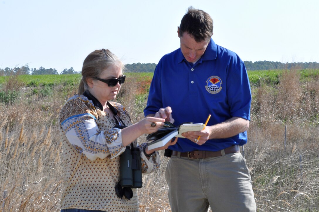 Angela Gray, U.S. Air Force Civil Engineer Center environmental analyst, and Tomas Olexa, 633rd Civil Engineer Squadron natural resources manager, examine a guide book to identify a bird during the Earth Week Bird Count at Langley Air Force Base, Va., April 23, 2014. The base hosts two annual bird counts, held in spring and winter. The data collected from these counts is shared with the 1st Fighter Wing Safety office and the local birding community. (U.S. Air Force photo by Master Sgt. April Wickes)