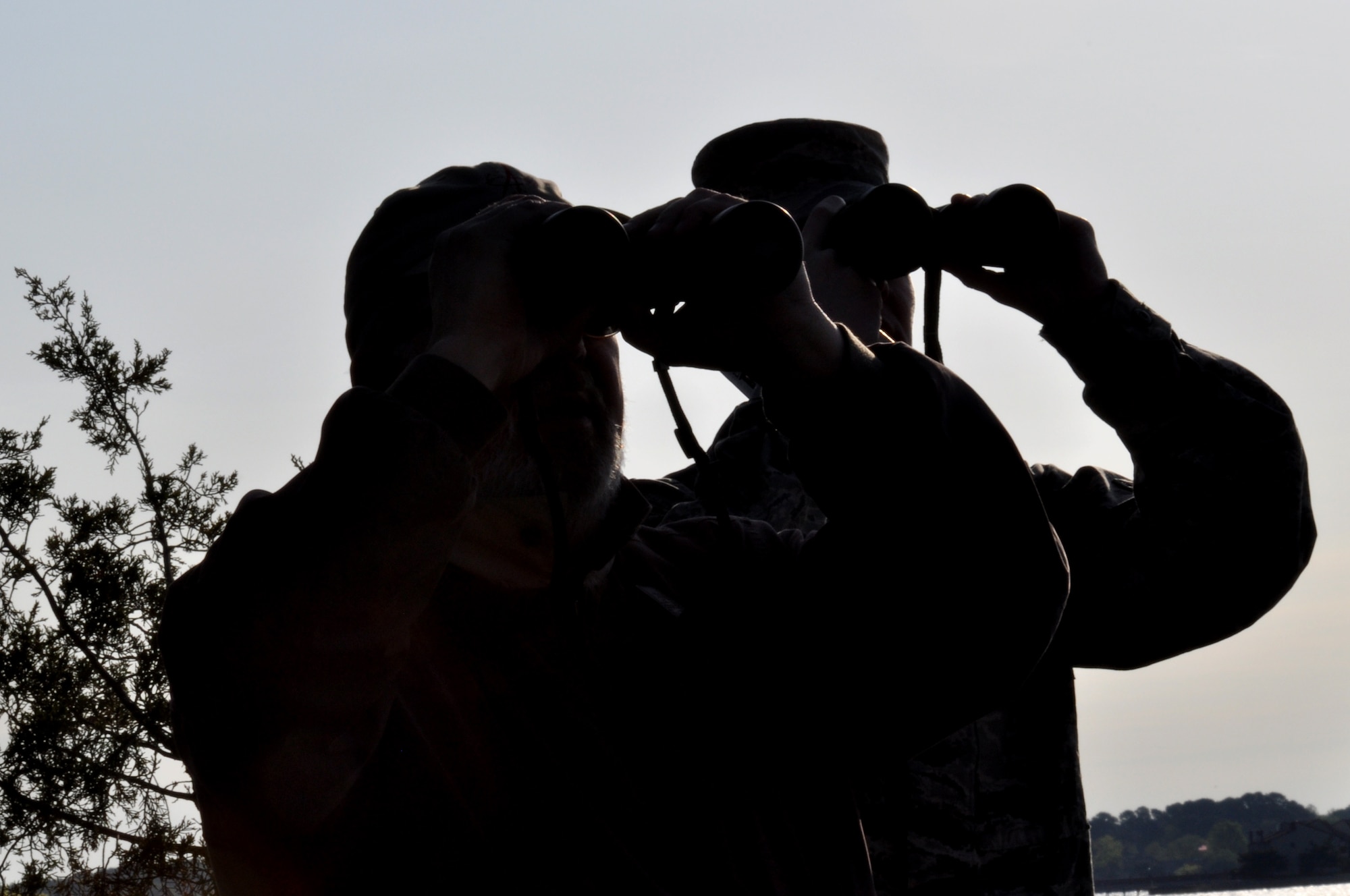 Vic Johnston, 633rd Air Base Wing Public Affairs director of community engagement, and Airman 1st Class Dale Sullivan, 633rd Logistics Readiness Squadron vehicle operator, watch birds through their binoculars during the Earth Week Bird Count at Langley Air Force Base, Va., April 23, 2014. More than 18,000 birds have been counted at Langley AFB. (U.S. Air Force photo by Master Sgt. April Wickes) 