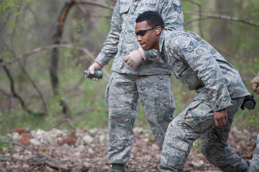 Airman 1st Class K'Shawn Joseph, 113th Wing Operations Support Flight, prepares to throw a M18 smoke grenade during a training session here, April 17. The training was hosted by the 11th Civil Engineer Squadron Explosive Ordnance Disposal unit. (U.S. Air Force photo/Staff Sgt. Robert Cloys)
