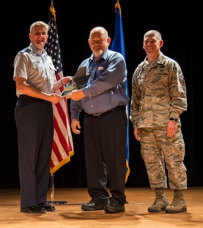 Col. Al Miller, 437th Airlift Wing vice commander (left), and Chief Master Sgt. Shawn Hughes, 437th AW command chief (right), present the Category II Civilian Award to Donald Norman, 437th Aerial Port Squadron load planning supervisor Apr. 24, 2014, at the Base Theater on Joint Base Charleston – Air Base, S.C. The Quarterly Awards are held to recognize outstanding Airmen, noncommisioned officers, senior noncomissioned officers, company grade officers and civilians for their hard work and dedication. (U.S. Air Force photo/ Airman 1st Class Clayton Cupit)