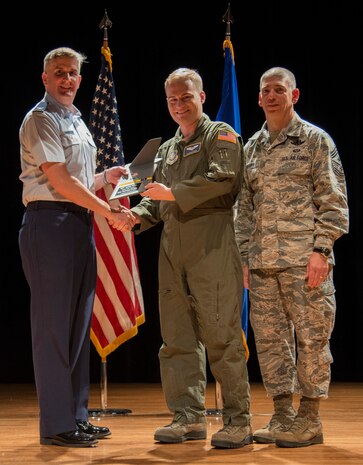 Col. Al Miller, 437th Airlift Wing vice commander (left), and Chief Master Sgt. Shawn Hughes, 437th AW command chief (right), present the Airman of the Quarter Award to Airman 1st Class Nicholas Stefan, 14th Airlift Squadron safety loadmaster Apr. 24, 2014, at the Base Theater on Joint Base Charleston – Air Base, S.C. The Quarterly Awards are held to recognize outstanding Airmen, noncommisioned officers, senior noncomissioned officers, company grade officers and civilians for their hard work and dedication. (U.S. Air Force photo/ Airman 1st Class Clayton Cupit)