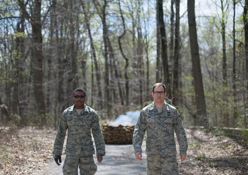 Airman 1st Class K'Shawn Joseph, 113th Wing Operations Support Flight, and Senior Airman Brian Mink, 11th Civil Engineer Squadron Explosive Ordnance Disposal technician, walk back to thier training group after deploying a ground burst simulator on the east side of Join Base Andrews, April 17. (U.S. Air Force photo/Staff Sgt. Robert Cloys)