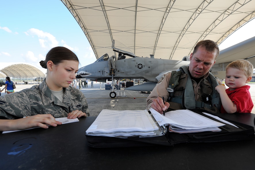 U.S. Air Force Capt. Leif Nordhagen, an A-10C Thunderbolt II pilot assigned to the 75th Fighter Squadron, holds his son Lars while completing post-flight forms with Airman 1st Class Robin Burke, an A-10 crew chief with the 23d Aircraft Maintenance Squadron.  Nordhagen returned to Moody following a six-month deployment to Afghanistan. 
(U.S. Air Force photo by Master Sgt. Sonny Cohrs/Released)
