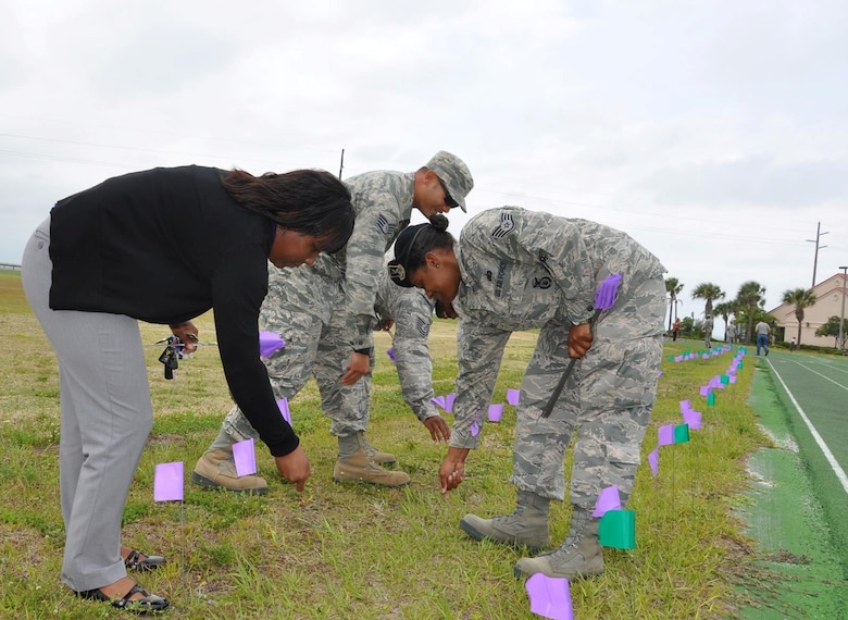 Team Patrick-Cape volunteers place 1,046-marker flags near the track at Patrick Air Force Base, Fla., April 18, 2014, to symbolize the number of reported sexual assault victims in the Air Force in 2013. The 45th Space Wing hosted a "Mile in her Shoes" run-walk, in conjunction with other Sexual Assault Awareness events during April. (U.S. Air Force photo/Capt. Erin Dorrance)
