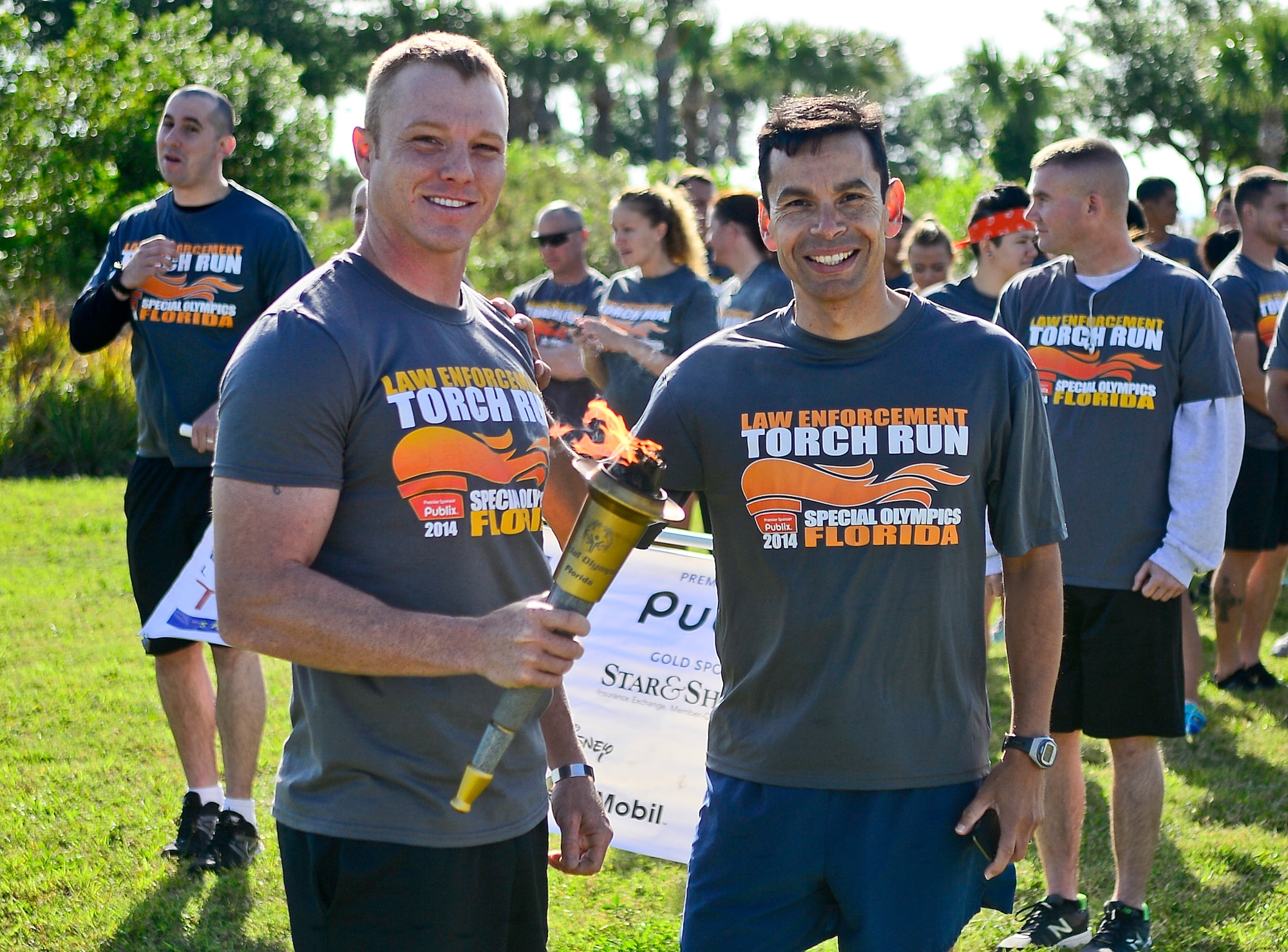 Staff Sgt. Shannon Hutto, 6th Security Forces Squadron military working dog trainer, and Col. Peter Santa Ana, 6th Mission Support Group commander, pose for a photo prior to the start of the Special Olympics Florida Law Enforcement torch run at MacDill Air Force Base, Fla., April 16, 2014. The 6th SFS has participated in this event since the mid 1990's. (U.S. Air Force photo by Senior Airman Melanie Bulow-Gonterman/Released)
