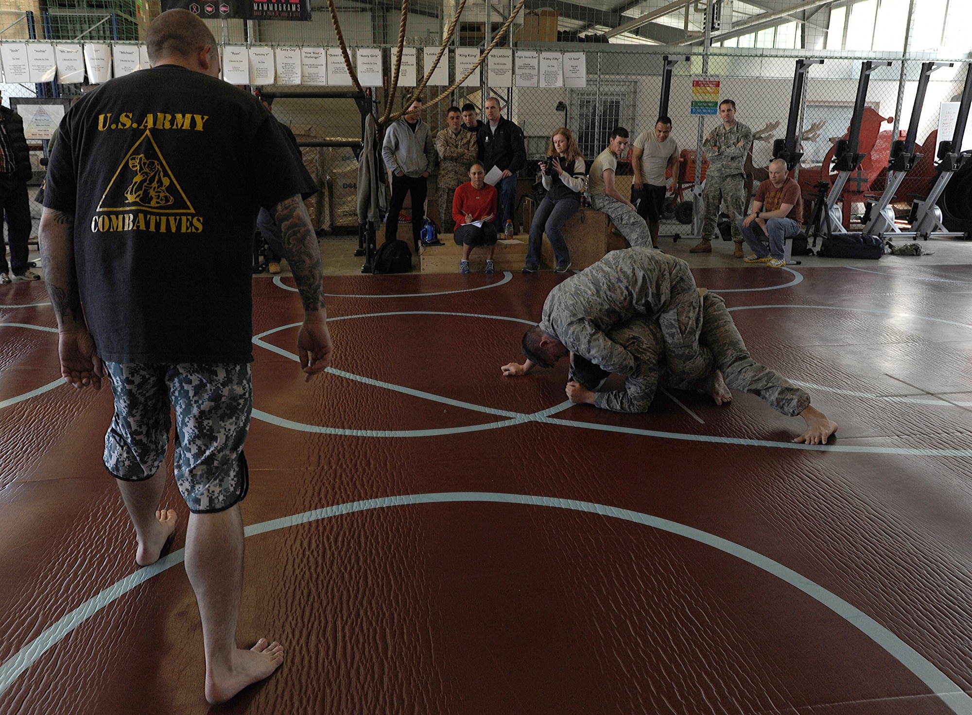 U.S. Army Sgt. 1st Class Jason Eccles, Public Health Command Region-Europe, supervises the championship match between U.S. Air Force 2nd Lt. Travis Seaver, 603rd Air and Space Communications Squadron deputy flight commander C2 systems, and U.S. Air Force Staff Sgt. Ryan Valdez, 603rd ACOMS RF transmission systems supervisor, during the final tournament of the Modern Army Combatives program, April 18, 2014, at Landstuhl Regional Medical Center. The Modern Army Combatives program is used to teach techniques from different mixed martial arts to members of all branches of the U.S. military to prepare for hand-to-hand combat situations. (U.S. Air Force photo/Airman 1st Class Holly Mansfield)