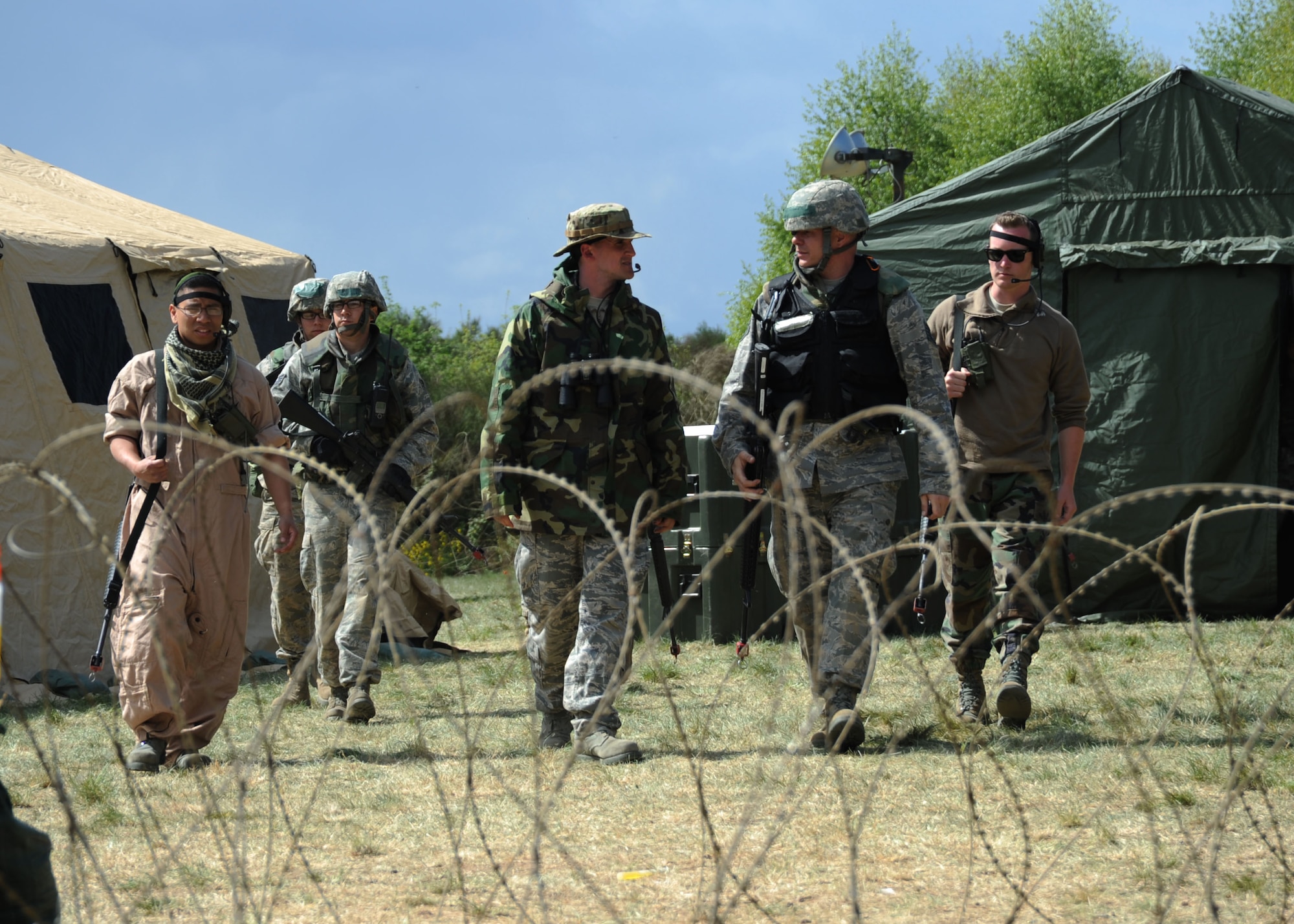 U.S. Air Force Airmen from the 606th Air Control Squadron escort a local leader after a visit during a combat readiness training exercise April 18, 2014, at Spangdahlem Air Base, Germany. Airmen learned how to interact with CRT augmentees posing as local leaders as part of the exercise. (U.S. Air Force photo by Airman 1st Class Dylan Nuckolls/Released)