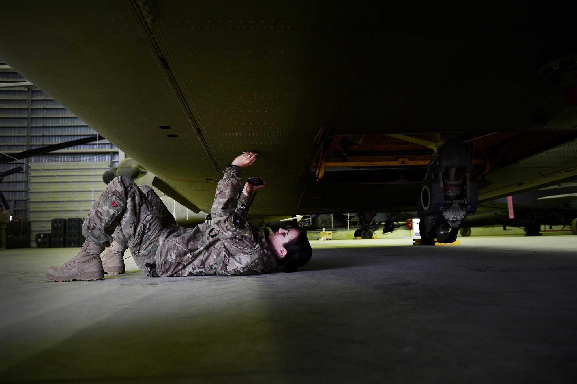 U.S. Air Force 1st Lt. Kelli Walker, 1st Combat Aviation Brigade, battle damage materials scientist, photographs a U.S. Army CH-47 Chinook, Kandahar Air Field, Afghanistan, March 14, 2014. As a Joint Expeditionary Tasked (JET) battle damage scientist, Walker is primarily responsible diagnosing all damage of unit aircraft, reporting recovery processes and providing scientific data to improve future aircraft restoration projects. She is a Roseville, Calif. native, deployed from the Manufacturing Directorate, Wright Patterson Air Force Base, Ohio. (U.S. Air Force photo by Staff Sgt. Vernon Young Jr.)
