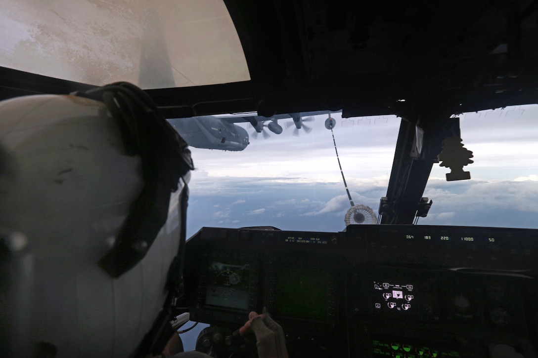 Marine Corps Capt. Ricky D. Buria watches a KC-130J Hercules aircraft refuel an MV-22 Osprey off the coast of North Carolina, April 14, 2014. Buria is a pilot assigned to the Marine Medium Tiltrotor Squadron 266.