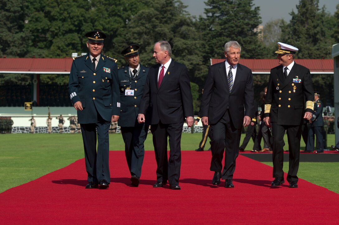 U.S. Defense Secretary Chuck Hagel, second from right, walks with Secretary of National Defense Gen. Salvador Cienfuegos Zepeda and Naval Secretary Adm. Vidal Francisco Soberon Sanz, Mexico's defense ministers, and Canadian Defense Minister Robert Nicholson after an honors ceremony in Mexico City, April 24, 2014. 
