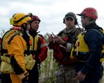 From left: Melchor Fernandez, Luke Schott and Jeff Keuper from Federal Emergency Management Agency's Texas Task Force 1, discuss a search-and-rescue mission with a joint terminal attack controller from the 147th Air Support Operations Squadron, 147th Reconnaissance Wing, based at Ellington Field Joint Reserve Base in Houston, Texas, during an exercise at Canyon Lake, Texas, April 11, 2014. 